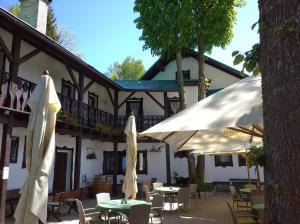 an outdoor patio with tables and umbrellas in front of a building at Hotel v Nebi in Josefŭv Dŭl