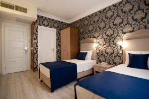 a hotel room with two beds and a door at Artefes Hotel Old City in Istanbul