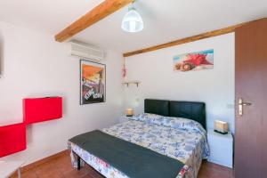 ein Schlafzimmer mit einem Bett in einem Zimmer mit roten Akzenten in der Unterkunft Bilocale in Villa Elba in Marina di Campo