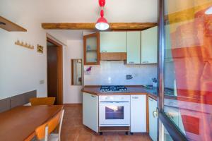 eine Küche mit einem weißen Herd oberer Ofen neben einem Tisch in der Unterkunft Bilocale in Villa Elba in Marina di Campo