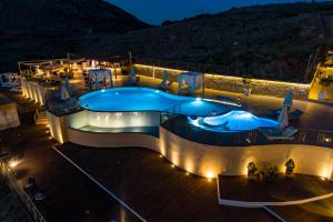 a pool on a cruise ship at night at Petani Bay Hotel - Adults Only in Vóvikes