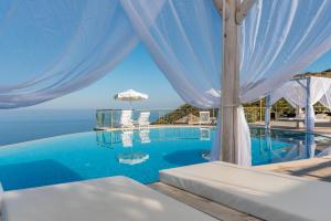 a view of the infinity pool at a resort at Petani Bay Hotel - Adults Only in Vóvikes