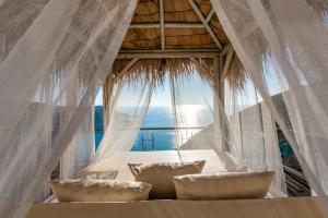a room with a bed with a large window at Petani Bay Hotel - Adults Only in Vóvikes