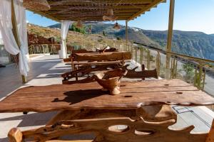 a wooden table on a deck with mountains in the background at Petani Bay Hotel - Adults Only in Vóvikes
