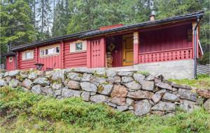 una cabina roja detrás de una pared de piedra en Høgesset, en Feiring