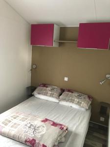 two beds in a room with purple cabinets and a bedvisor at Mobile Homes by KelAir at Camping L'Hippocampe in Argelès-sur-Mer