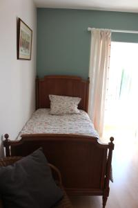 a small bed in a room with a window at Zelda in Roôcourt-la-Côte +5 photos