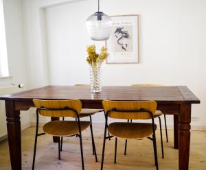 a dining room table with chairs and a vase with flowers at Bright apartment next to the King's Garden in Copenhagen