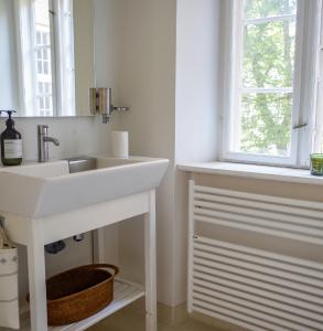 a bathroom with a white sink and a window at Bright apartment next to the King's Garden in Copenhagen