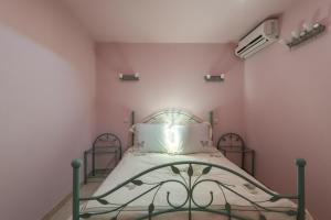 Cama en habitación con paredes rosas en Fleur des Champs, en Saint-Germain 10 fotos más