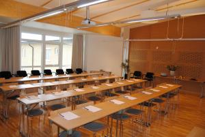 a large room with rows of tables and chairs at Arena Hotell in Vänersborg