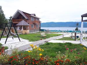 a park with a house and a playground with flowers at Hotel complex Baikalskiy Rai in Kultuk
