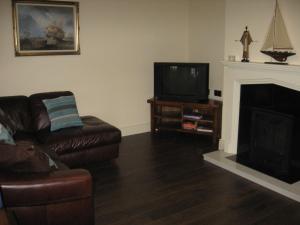 a living room with a couch and a television at Castle View Cottage in Irvinestown