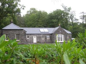 a large stone house with a solar roof at Castle View Cottage in Irvinestown