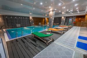 a swimming pool with several chairs and a swimming pool at Gudauri, Atrium Suites in Gudauri