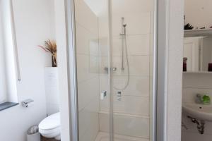 um chuveiro com uma porta de vidro na casa de banho em Oberkasseler Hof Bonn em Bonn