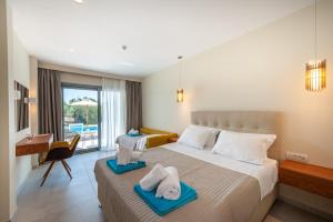 Habitación de hotel con cama y escritorio con toallas en Alonaki Resort en Preveza
