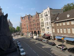 une rue de la ville avec des voitures garées dans la rue dans l'établissement Hotel La Belle Vue, à Amsterdam