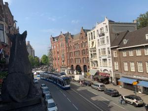 アムステルダムにあるHotel La Belle Vueの建物のある街路を走るバス
