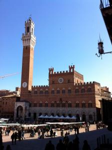a large building with a clock tower in front of it at Antica Residenza Cicogna in Siena
