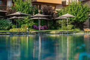 a swimming pool with umbrellas and tables and chairs at HVD Club Hotel Miramar - 24 Hours Ultra All Inclusive in Obzor