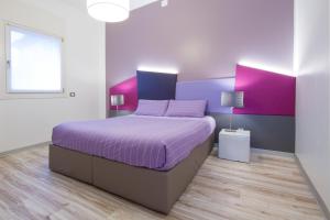 a bedroom with a purple bed and a window at Casa Stucky in Udine