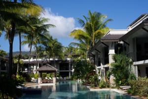 a view of the resort with a swimming pool and palm trees at Pullman Port Douglas Sea Temple Resort and Spa in Port Douglas