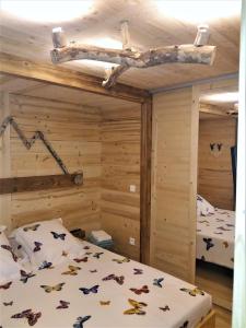 - une chambre avec 2 lits et des bûches au plafond dans l'établissement Appartement 2 pièces cuisine Les Hermines, à Saint-Nicolas-la-Chapelle