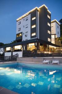 a hotel with a swimming pool in front of a building at Hotel Amicus in Mostar