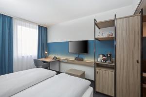 Postel nebo postele na pokoji v ubytování H4 Hotel Leipzig