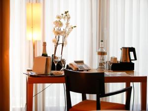 een bureau met een telefoon en een fles wijn bij Hotel Begardenhof in Keulen