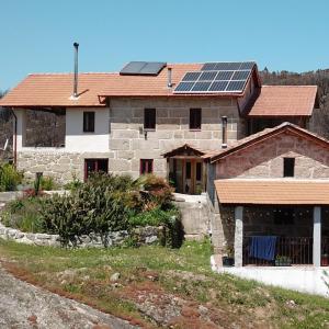 ein Haus mit Sonnenkollektoren auf dem Dach in der Unterkunft Quinta do Cobral in Oliveira do Hospital