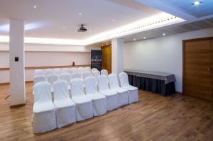 una habitación vacía con sillas blancas y una mesa en Hotel Serrano, en Córdoba