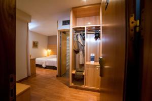 a room with a bed and a door leading to a bedroom at Hotel Serrano in Córdoba