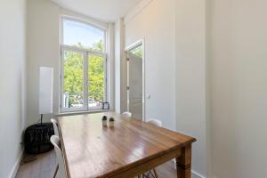 a dining room with a wooden table and two windows at Canal view apartment in the center of Amsterdam - Apt 1 in Amsterdam