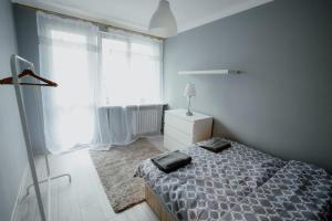 a bedroom with a bed and a large window at High Standard-University District free parking in Łódź