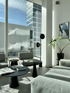 a living room with a couch and tables and a large window at STAY Bryggen in Copenhagen