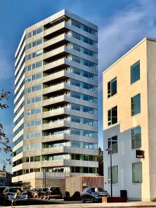 een hoog gebouw met auto's geparkeerd voor het bij STAY Bryggen in Kopenhagen