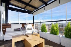 a living room with white furniture and large windows at Vivaldi Penthouse Ayuntamiento in Valencia