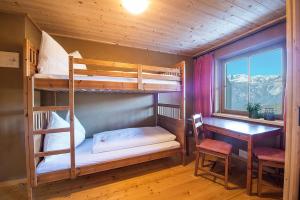 een kamer met 2 stapelbedden, een bureau en een raam bij Leitnhof in Reith im Alpbachtal