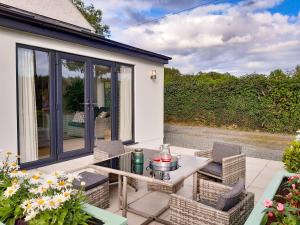 een patio met stoelen en een tafel op een huis bij Talfan Cottage in Gaerwen