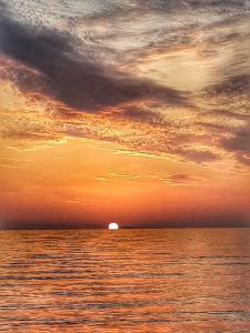 einen Sonnenuntergang über dem Meer mit der Sonne in der Ferne in der Unterkunft A casa da putìa, l'emozione di un tramonto in Milazzo