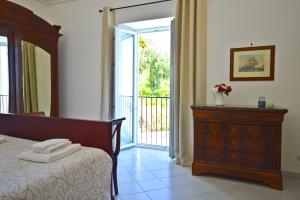 a bedroom with a bed and a dresser and a sliding glass door at Villa Azzurra in Conca dei Marini