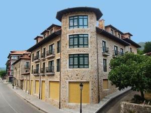 a large brick building on the side of a street at Hotel Villa de Cabrales in Arenas de Cabrales