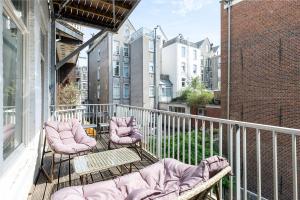 a balcony with two chairs and a couch on it at Comfortable central apartment with private balcony in Amsterdam