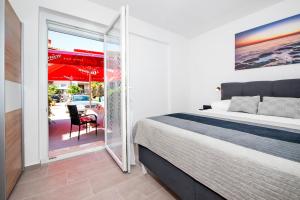 a bedroom with a bed and a balcony with a chair at Studio Istra in Rovinj