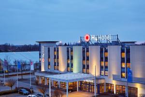 un edificio de hotel con un cartel encima en H4 Hotel Leipzig, en Leipzig