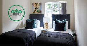 two beds in a room with a sign on the wall at Aisiki Living at Alexandra Road, 2-Bedroom & 2-Bathroom with King or Twin Beds with Free Wi-Fi and Parking Space in Watford