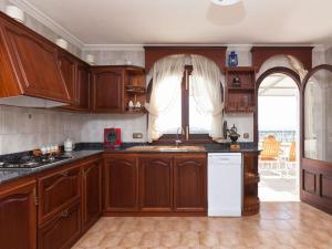 - une cuisine avec des placards en bois et un réfrigérateur blanc dans l'établissement Casa de Can Riera con Piscina Comunitaria, à Moscari