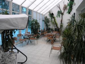 a dining room with tables and chairs and plants at SPA Hotel in Vorzelʼ